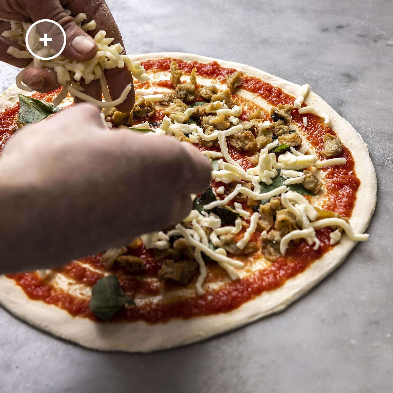 adding toppings on pizza