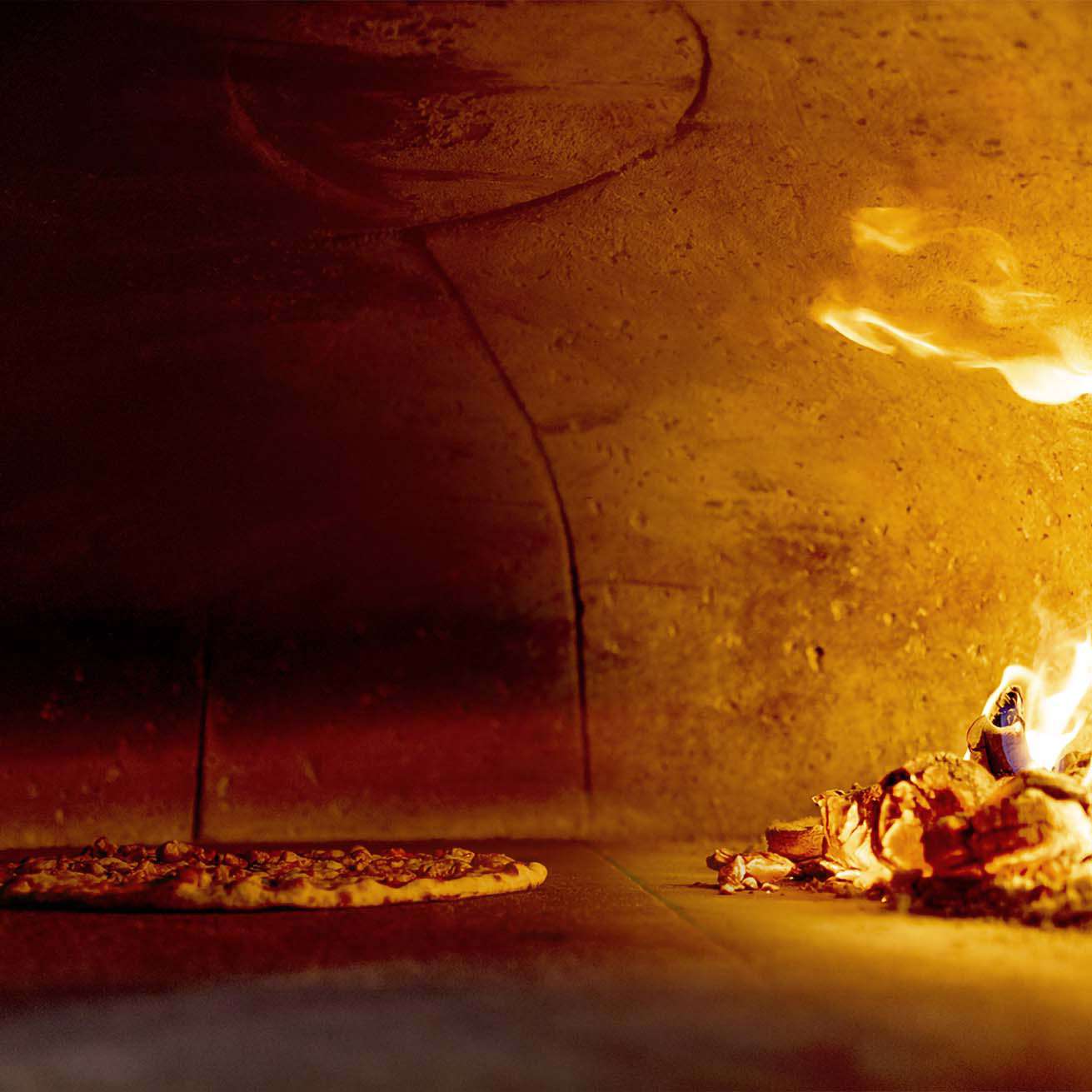 a pizza is being baked in a wood oven.