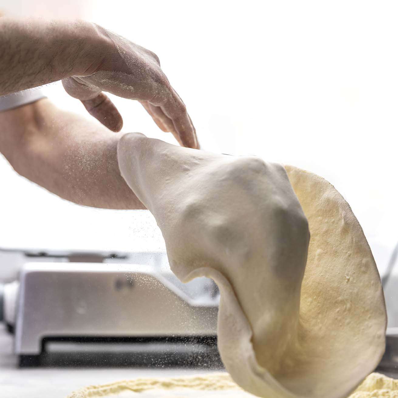 expert pizza-maker working on the dough